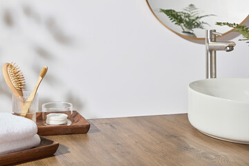 Open wooden tray with glass, toothbrush, and accessories on spacious wooden counter. Mirror...