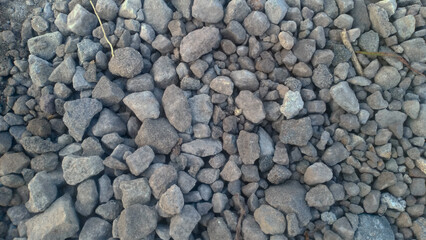 A collection of small gravel stones commonly used for construction, landscaping, or as a base layer in roads and pathways. These pebbles vary in size and color, offering a natural and durable surface.
