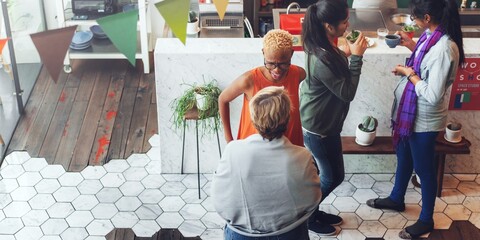Group of diverse people socializing in a cozy cafe. Warm atmosphere with friends chatting, enjoying...