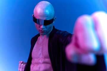 Dynamic man striking a pose with a bold attitude, showcasing strength and determination in a surreal blue light setting. A captivating black and white image.