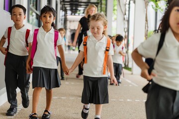 Young children, boys and girls, in school uniforms, walking together. Elementary school uniforms,...