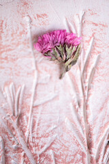 florecita rosada sobre material de arcilla con textura color palo de rosa