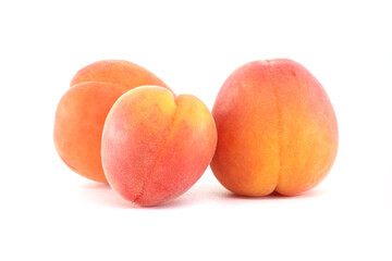 Three Ripe Apricots Isolated on a White Background in Studio Light
