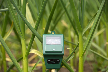 Soil Analyzer Device Amidst Green Plants for Agricultural Measurement Concepts