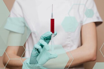 Nurse with a syringe in her gloved hand
