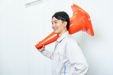 カラーコーンを持つ男性