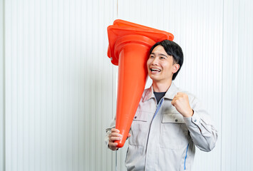 カラーコーンを持つ男性
