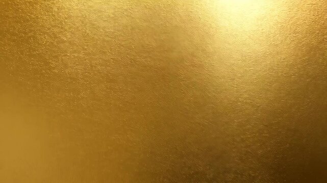 Elegant golden surface with textured pattern shimmering with reflected light in a diagonal sweep of soft light