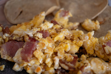 huevo revuelto con tocino y pedazos de tortilla
