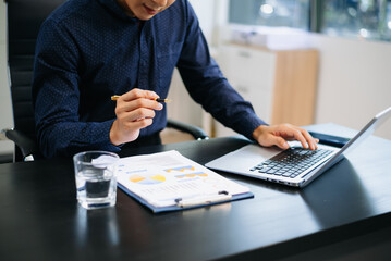 man multitasking with smartphone and laptop in bright modern office. Ideal for business, remote...