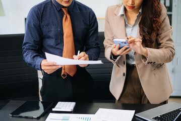 Closeup of business professionals analyzing graphs and financial reports together. Ideal for teamwork, finance, corporate planning