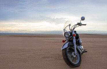 Off-road motorcycle standing still in the open desert beneath heavy clouds. A strong visual of freedom, rugged adventure, and the thrill of riding through wild, untamed terrain.