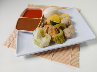 Siomay Bandung (Shumay) or steamed dumplings with boiled egg, tofu, potato, bitter melon and...