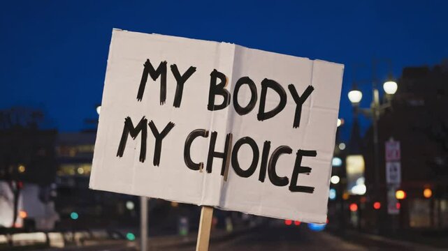 A "MY BODY MY CHOICE" sign prominently held up by a person in a crowd, emphasizing bodily autonomy and social advocacy. Ideal for human rights or protest content.
