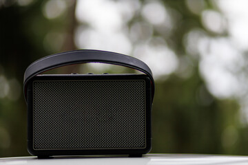 Portable square speaker on the table, listen to music in the middle of nature, carry music with you while traveling, portable music