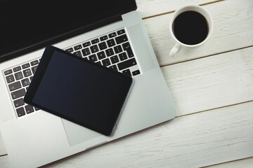 Laptop with coffee mug on wooden table