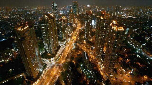 Cityscape at Night: An expansive aerial view of a sprawling city illuminated by countless lights at night. The vibrant urban landscape stretches far into the distance.