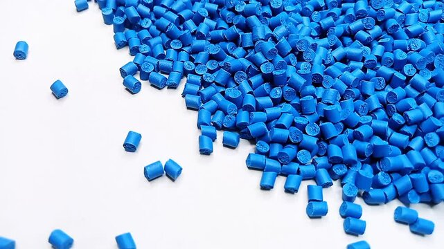 blue masterbatch granules are poured into a white background, the video surrounds the cold cutting type masterbatch, as a videography design for an industrial plastic company