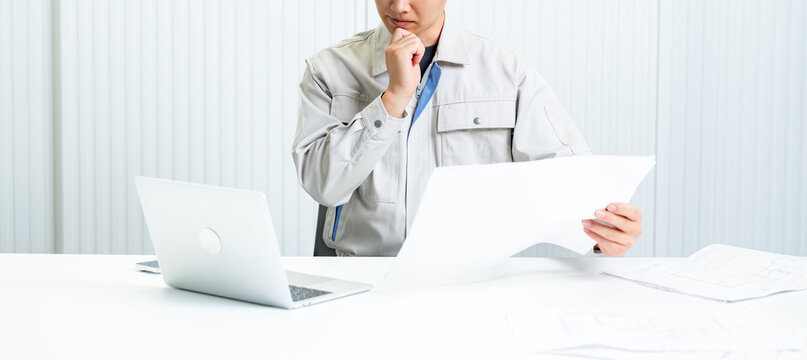 考える作業着を着た男性