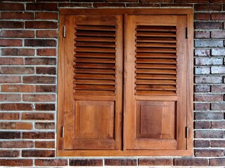 Closed wooden shutters blend with exposed brick walls