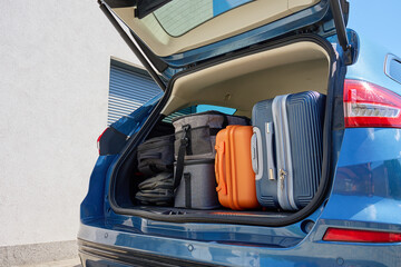 Full car trunk packed with suitcases, backpacks and bags. Vehicle filled with luggage ready for...
