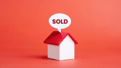 A Small Toy House with a Red Roof and a Speech Bubble Indicating 'Sold' Against a Bright Orange Background, Symbolizing Real Estate Success.