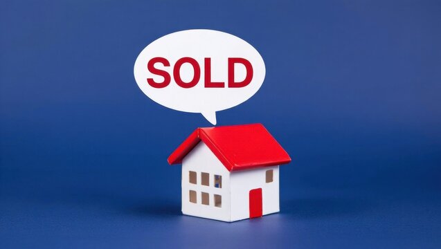 Miniature Model House with a Speech Bubble Indicating 'SOLD' to Represent Real Estate Transactions and Successful Property Sales