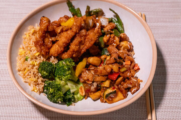 Close-up of colorful Chinese takeout with chopsticks on a rustic wood table, showcasing vibrant stir-fry noodles, vegetables, and dumplings—perfect for food blogs, menus, or cultural features.