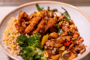 Close-up of colorful Chinese takeout with chopsticks on a rustic wood table, showcasing vibrant stir-fry noodles, vegetables, and dumplings—perfect for food blogs, menus, or cultural features.