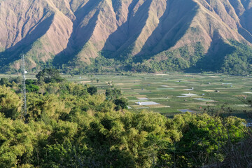 Majestic view of Pergasingan Hill glowing under soft morning light, seen from Selong Hill in Sembalun, Lombok—where dramatic ridgelines meet tranquil rural charm.