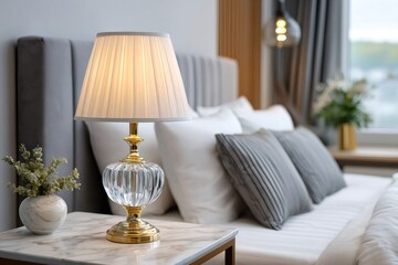 Elegant lit lamp standing on bedside table in hotel room
