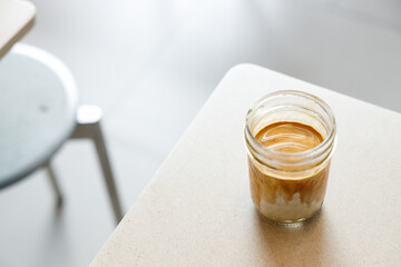 Cup of milk dirty coffee on table by the window.