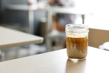 Cup of milk dirty coffee on table by the window.