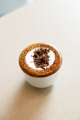 Cup of hot milk chocolate mocha coffee on table by the window.