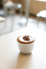 Cup of hot milk chocolate mocha coffee on table by the window.