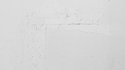 Close up view of a distressed white concrete wall with cracking and peeling paint, creating a...