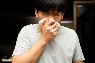 Man Sneezing into Tissue. Health and Allergy Concept. man sneezing into a tissue, illustrating...