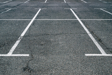 Empty parking lots with asphalt flooring and white marking lines