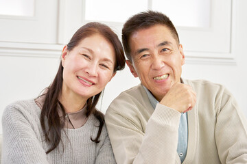 シニアの夫婦　笑顔　カメラ目線　ポートレート　リビング