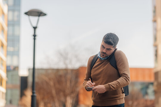 Journalist taking notes outdoors in urban setting