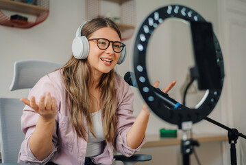 Young woman recording podcast, singing or making video call using ring light and microphone