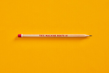 Pencil challenging artificial intelligence on yellow background