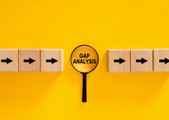 Magnifying glass focusing on gap analysis between two sets of wooden blocks with arrows pointing...