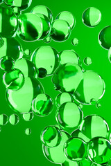 Glossy green 3D bubbles floating on a vibrant background. Abstract design symbolizing freshness,...