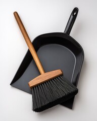 Black metal dustpan and broom, wooden handle