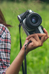 Vertical Asian Women with vintage film camera take a photo. Smiling female photographer look at...