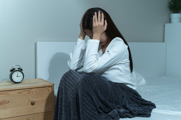 Young woman sleepless during night time on the bed.