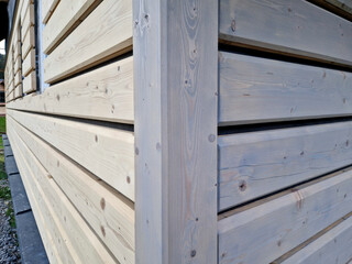 Carpenter built a log cabin with rough hewn beams. Planing wood. Authentic artisanal wooden log...