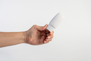 Skin care or sunscreen cosmetic and hand on white background.