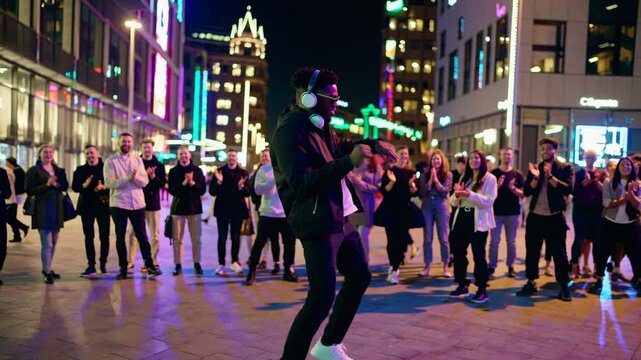 Dancer leading energetic street dance performance at night with group crowd behind, illuminated urban plaza scene capturing youth culture, entertainment, unity, and modern expression